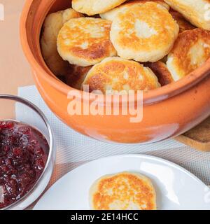 Crêpes au fromage cottage dans une assiette et un pot d'argile, avec confiture sur une table de serveurs délicieux dessert au fromage cottage. Photo de haute qualité Banque D'Images