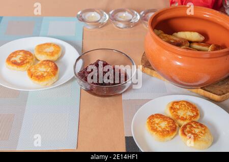 Crêpes au fromage cottage dans une assiette et un pot d'argile, avec confiture sur une table de serveurs délicieux dessert au fromage cottage. Photo de haute qualité Banque D'Images