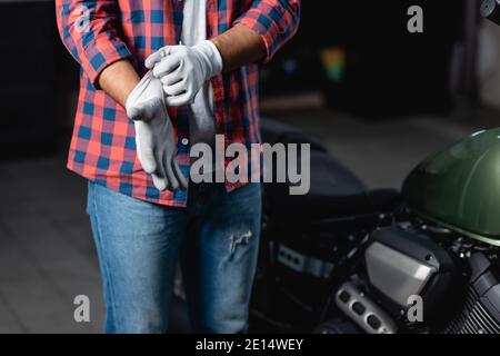 coupe courte de mécanicien avec chemise à carreaux et jean sur les gants en atelier Banque D'Images