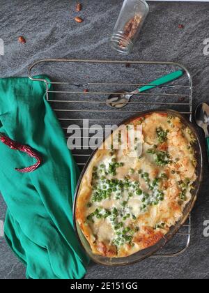 Lasagnes maison aux pois verts dans une nappe verte Banque D'Images