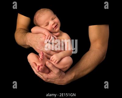 Mains d'un jeune père tenant son 7 jours nouveau-né bébé garçon sur fond noir Banque D'Images