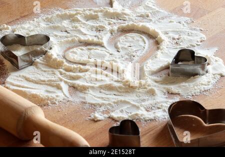 Moule à biscuit sur fond de bois arrosé de farine. Noël, nouvel an, préparation des vacances et concept de créativité. Banque D'Images