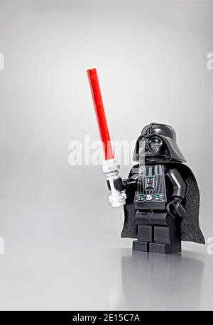 LEGO Darth Vader avec sabre laser photographié sur fond gris Banque D'Images