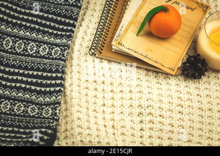 Arrière-plan d'hiver avec des chandails tricotés, des livres et des mandarines, concept de confort à la maison sur des vacances confortables, copie de l'espace photo Banque D'Images