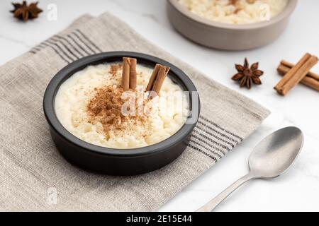 Riz crémeux au lait de cannelle dans un bol sur une table en marbre blanc. Dessert espagnol typique Banque D'Images