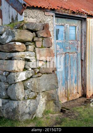 South Harris, Isle of Lewis et Harris, Écosse : ancien hangar coloré avec une porte bleue Banque D'Images