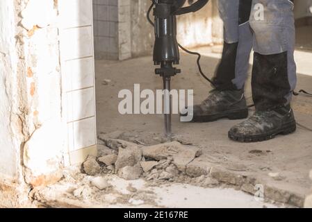 Travailleur sur le chantier de construction avec UN marteau en panne - gros plan Banque D'Images