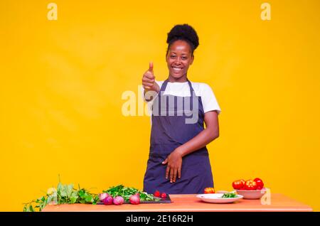 une jeune femme africaine se sent excitée dans la cuisine pendant elle a fait le pouce Banque D'Images