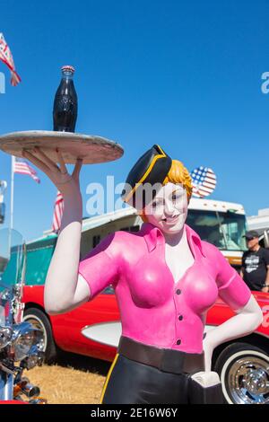 Mannequin d'époque d'un serveur de saut à la ligne féminin sur patins à roulettes avec coke sur un plateau au salon automobile américain classique Stars & Stripes Banque D'Images