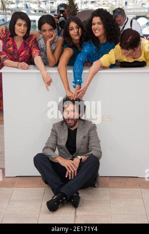 Le réalisateur Radu Mihaileanu (assis) pose avec (G-D) Hiam Abbas, Hafsia Herzi, Leila Bekhti, Sabrina Ouazani et Biyouna à un photocall pour le film "The Source" (titre original: 'La Source des femmes') présenté en compétition dans la section longs métrages dans le cadre du 64ème Festival international du film de Cannes, au Palais des Festivals de Cannes, dans le sud de la France, le 21 mai 2011. Photo de Hahn-Nebinger-Genin/ABACAPRESS.COM Banque D'Images