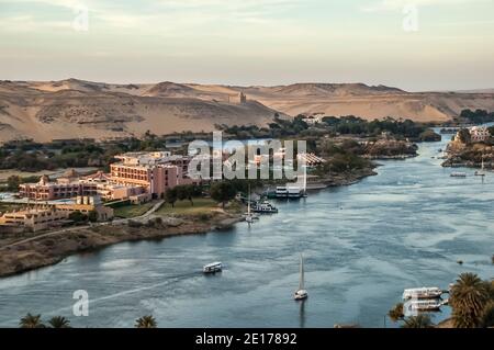 Cette scène tranquille avec des voiliers de Felucca sur le Nil se trouve dans l'ancienne ville égyptienne d'Assouan, connue auparavant sous le nom de ville nubienne, en regardant vers le sud vers le site de sépulture des tombes des Nobles et le Mausolée de l'Aga Khan. La région est importante car elle était un poste de transit pour l'armée britannique qui passait par l'Égypte au Soudan d'où Lord Kitchener a rétabli la paix dans la région. Pour cela, il a été doué de la terre connue sous le nom de Kitcheners Island que Lord Kitchener a transformée en l'un des premiers jardins botaniques au monde Banque D'Images