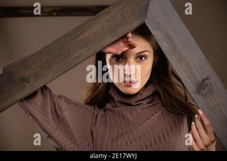 portrait de mode de fille dans le studio sur un fond de décor en bois Banque D'Images