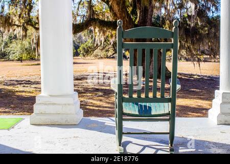 Une chaise à bascule vide sur le porche avant d'une maison de style avant-guerre dans le sud des États-Unis. Banque D'Images