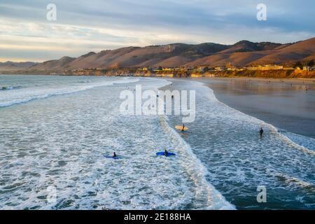 Pismo Beach, Californie, États-Unis - 1er janvier 2021 Océan Pacifique à marée haute et surfeurs. Collines d'or et beau ciel nuageux en arrière-plan. Pismo BEAC Banque D'Images