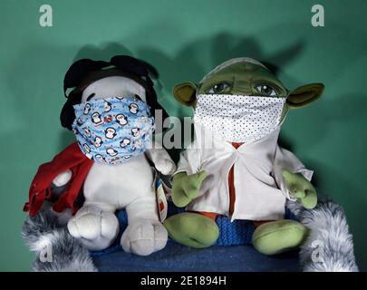 Ours en peluche animal Snoopy de dessin animé et bébé Yoda du film de la guerre des étoiles portant des masques faciaux pendant la pandémie covid-19 de 2020 Banque D'Images