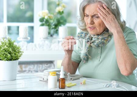 Portrait de senior malade woman sitting at table Banque D'Images