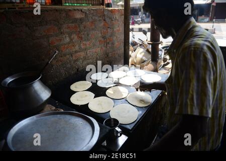 Un Tamoul cuire la préparation d'un Dosa. Banque D'Images