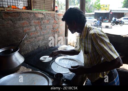 Un Tamoul cuire la préparation d'un Dosa. Banque D'Images