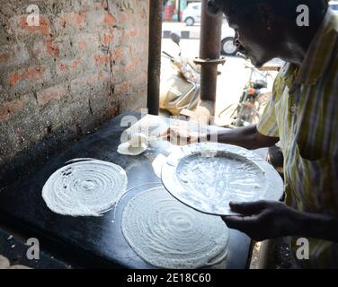 Un Tamoul cuire la préparation d'un Dosa. Banque D'Images