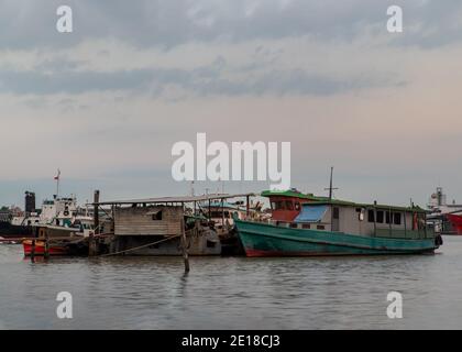 Bangkok, Thaïlande - 04 janvier 2021 : UN petit cargo stationné devant le petit quai de la rivière Chao Phraya. Mise au point sélective. Banque D'Images