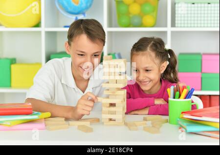 Frère et sœur jouant avec des blocs de bois dans la salle de jeux Banque D'Images