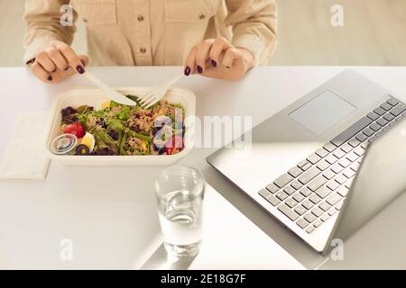 Étudiant occupé ayant un déjeuner sain à emporter dans le conteneur de repas pendant jour ouvrable Banque D'Images