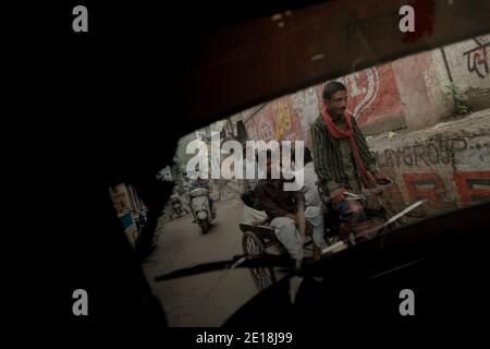 Pousse-pousse transportant des passagers, se déplaçant dans une rue étroite à Varanasi, Uttar Pradesh, Inde. Banque D'Images