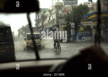 Véhicules négociant avec une route inondée d'eau de pluie pendant une forte pluie à Jaipur, Rajasthan, Inde. Banque D'Images