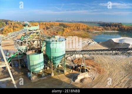 Gravier : chargement de gravier sur un camion par une chargeuse sur pneus et un bâtiment Banque D'Images