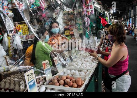 Manille, Philippines. 5 janvier 2021. Les vendeurs portant des masques ont tendance à s'occuper des clients sur un marché à Manille, aux Philippines, le 5 janvier 2021. L'inflation annuelle aux Philippines s'est accélérée pour atteindre 3.5 pour cent en décembre 2020, contre 3.3 pour cent en novembre 2020, tirée par les augmentations des aliments et des boissons non alcoolisées, a déclaré mardi l'Autorité statistique philippine (PSA). Dennis Mapa, chef de PSA, a déclaré à une conférence de presse virtuelle que c'était l'inflation la plus élevée enregistrée depuis mars 2019. Crédit: Rouelle Umali/Xinhua/Alamy Live News Banque D'Images