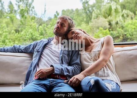 Thoughtful couple sitting on sofa Banque D'Images