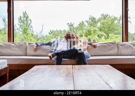 Smiling couple sitting on sofa Banque D'Images