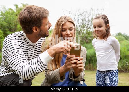 Famille heureuse utilisant un smartphone Banque D'Images