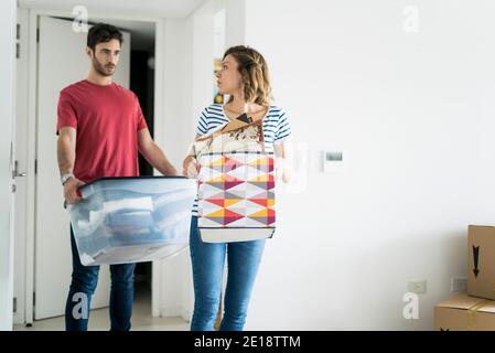 Jeunes couples transportant des boîtes dans leur nouvelle maison Banque D'Images