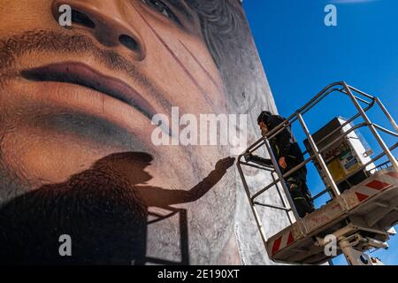 Naples, Italie. 04e janvier 2021. Jorit Agoch, artiste de rue napolitaine, a créé sa nouvelle fresque en Quarto, dans la province de Naples, représentant le visage de Diego Armando Maradona, décédé le 25 novembre 2020, Dique Luján, Argentine, ancien joueur de la ssc napoli de 1984 à 1991. La figure de maradona à naples et dans la province est vénérée comme un saint. Crédit : Agence photo indépendante/Alamy Live News Banque D'Images