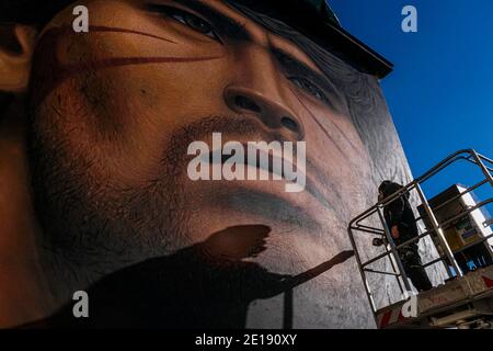 Naples, Italie. 04e janvier 2021. Jorit Agoch, artiste de rue napolitaine, a créé sa nouvelle fresque en Quarto, dans la province de Naples, représentant le visage de Diego Armando Maradona, décédé le 25 novembre 2020, Dique Luján, Argentine, ancien joueur de la ssc napoli de 1984 à 1991. La figure de maradona à naples et dans la province est vénérée comme un saint. Crédit : Agence photo indépendante/Alamy Live News Banque D'Images