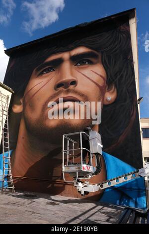 Naples, Italie. 04e janvier 2021. Jorit Agoch, artiste de rue napolitaine, a créé sa nouvelle fresque en Quarto, dans la province de Naples, représentant le visage de Diego Armando Maradona, décédé le 25 novembre 2020, Dique Luján, Argentine, ancien joueur de la ssc napoli de 1984 à 1991. La figure de maradona à naples et dans la province est vénérée comme un saint. Crédit : Agence photo indépendante/Alamy Live News Banque D'Images