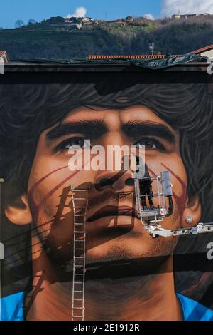 Naples, Italie. 04e janvier 2021. Jorit Agoch, artiste de rue napolitaine, a créé sa nouvelle fresque en Quarto, dans la province de Naples, représentant le visage de Diego Armando Maradona, décédé le 25 novembre 2020, Dique Luján, Argentine, ancien joueur de la ssc napoli de 1984 à 1991. La figure de maradona à naples et dans la province est vénérée comme un saint. Crédit : Agence photo indépendante/Alamy Live News Banque D'Images