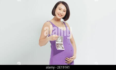 Femme enceinte asiatique montrent à l'échographie bébé sur fond blanc Banque D'Images