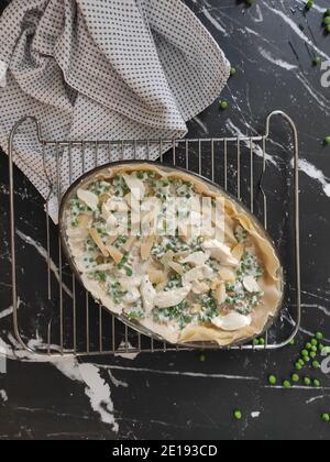 Lasagnes aux pois verts faits maison dans un fond sombre et un nappe verte Banque D'Images