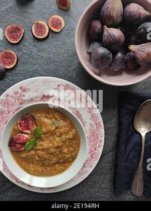 Figues violettes dans une soupe d'orange dans un ancien anglais bol de style Banque D'Images