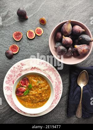 Figues violettes dans une soupe d'orange dans un ancien anglais bol de style Banque D'Images