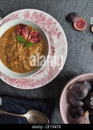 Figues violettes dans une soupe d'orange dans un ancien anglais bol de style Banque D'Images