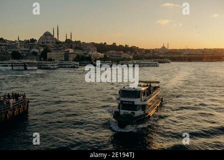 Un bateau touristique navigue sur la Corne d'Or, magnifique front de mer pittoresque et ensoleillé d'Istanbul au coucher du soleil en été. Concept de voyage et de vacances en I Banque D'Images