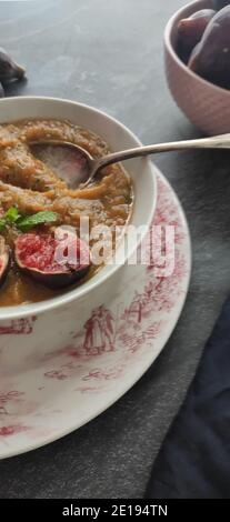 Figues violettes dans une soupe d'orange dans un ancien anglais bol de style Banque D'Images