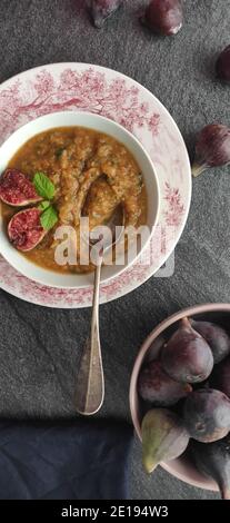 Figues violettes dans une soupe d'orange dans un ancien anglais bol de style Banque D'Images