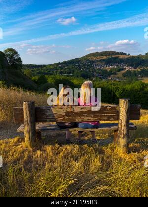 Deux personnes sur un banc en bois admirant la vue près de Wirksworth et Cromford dans le Derbyshire Dales partie du Peak District England UK en été. Banque D'Images