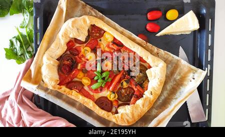 Pizza maison avec tomates fraîches et un peu de basilic Banque D'Images