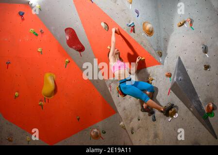 Gymnase d'escalade. Jeune femme Climber Bouldering. Sport extrême et escalade en intérieur Banque D'Images