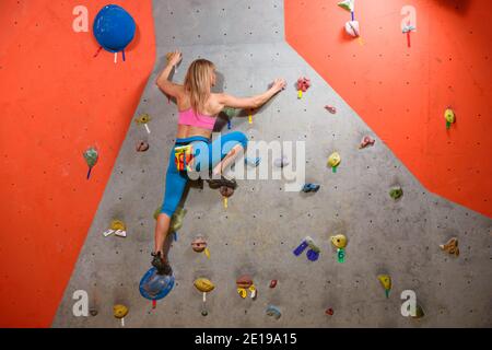 Gymnase d'escalade. Jeune femme Climber Bouldering. Sport extrême et escalade en intérieur Banque D'Images